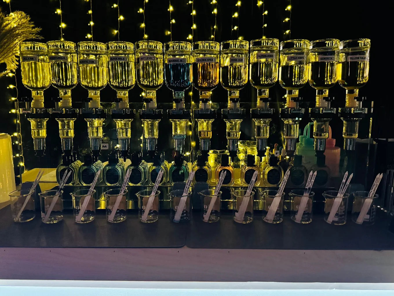 Bar setup with shelves of bottles and perfume shakers on a dark background